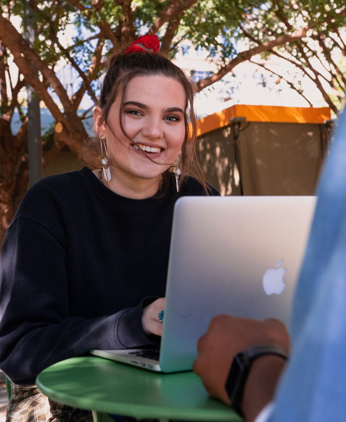 Candidate souriante travaillant sur son ordinateur portable en terrasse